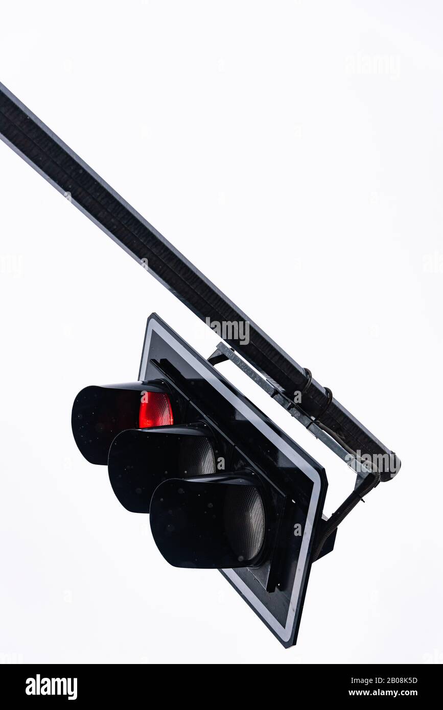 Detail einer Ampel mit roter Ampel. Blick auf eine schwarze Tragkonstruktion gegen einen klaren weißen Himmel Stockfoto