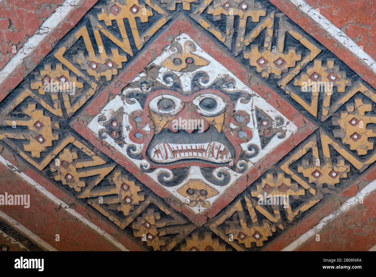 Bemalte und geschnitzte Reliefe des gottes Ayapec aus der präinkanisch-mochicanischen Kultur an den adobe-wänden der Huaca de la Luna bei Trujillo, Peru Stockfoto