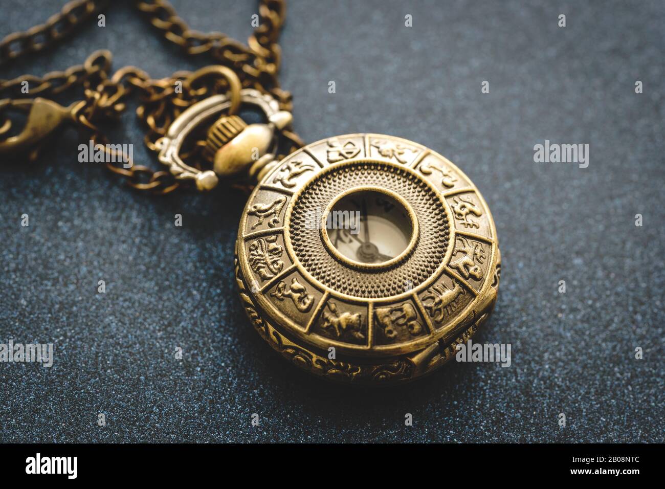 Detail einer Taschenuhr aus Metall mit Horoskopdesign Stockfoto