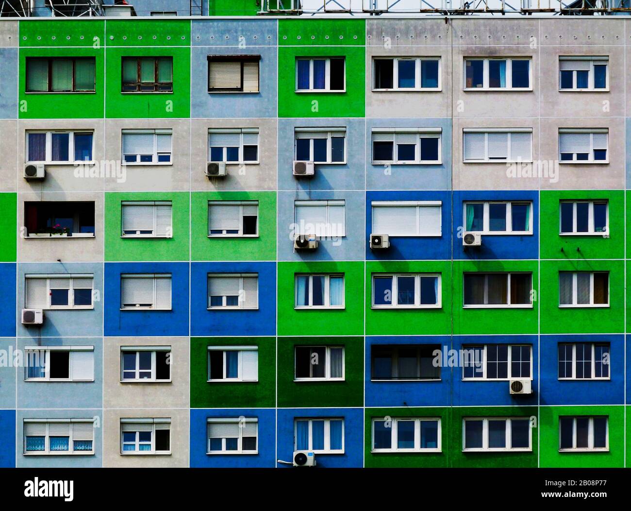 Äußere Höhendetails des neu isolierten abstrakten Betonpaneelgebäudes in Budapest mit vielen Fenstern und Klimaanlagen. Eigenheim. Stockfoto