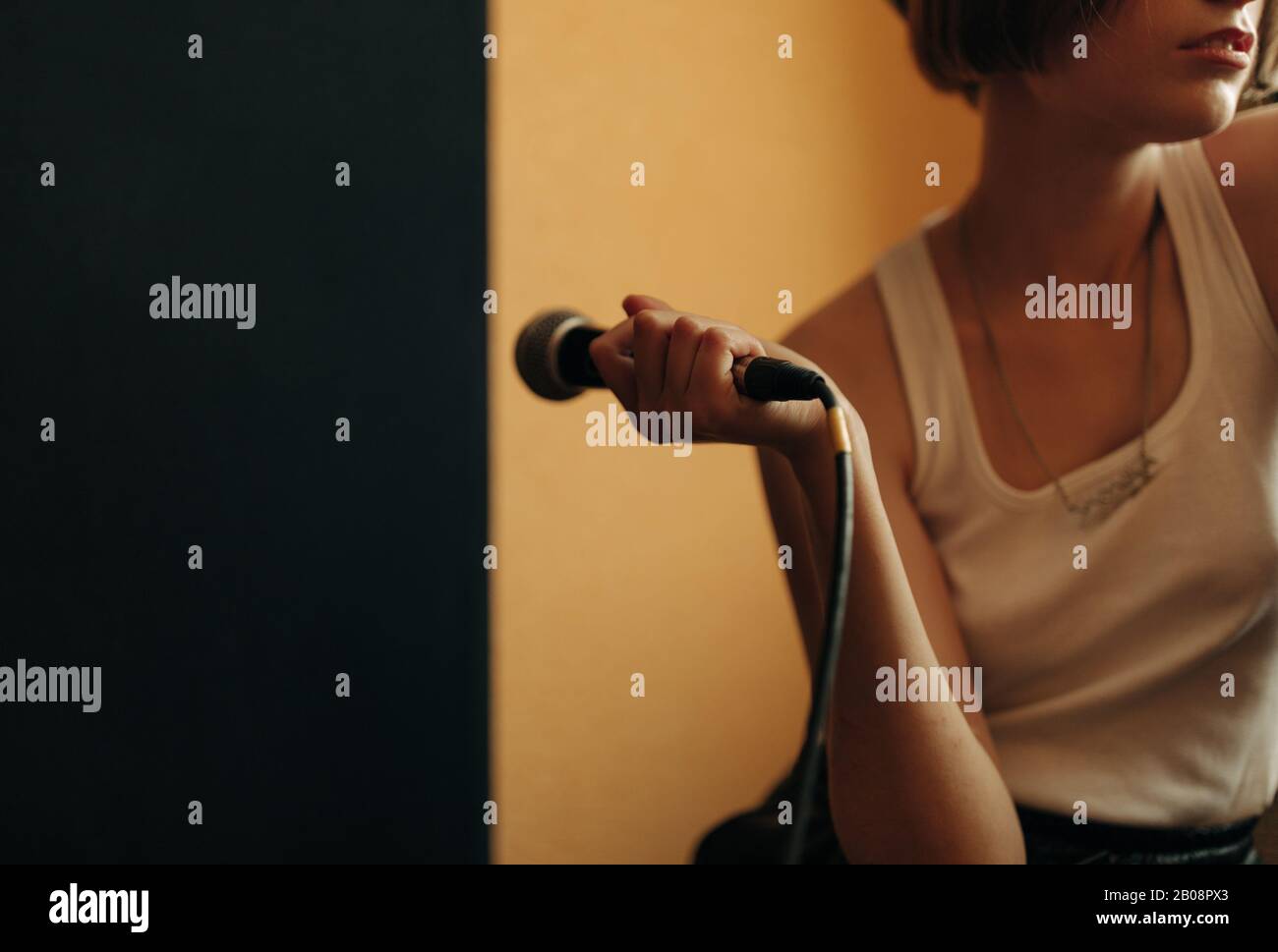 Junger Musiker mit Mikrofon im Tonstudio Stockfoto