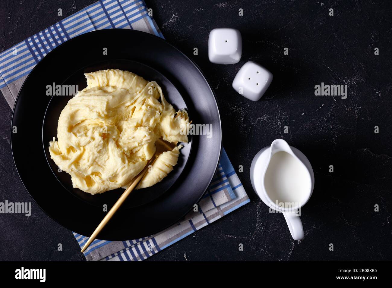 Aligot, kitschige Kartoffelform auf schwarzem Teller mit Gabel, französische Küche, horizontaler Blick von oben, flacher Lay Stockfoto