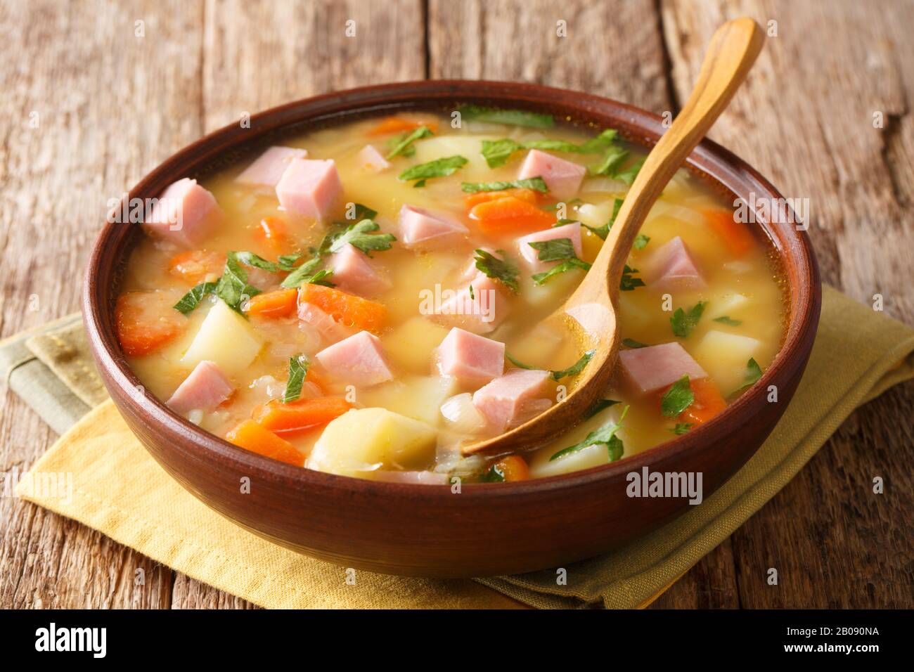 Servieren von geteilter Erbsensuppe mit Schinken in einer Schüssel auf dem Tisch. Horizontal Stockfoto