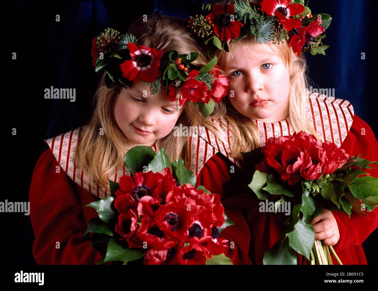 Zwei Brautjungfern in roten Kleidern, die Anaenomien halten Stockfoto