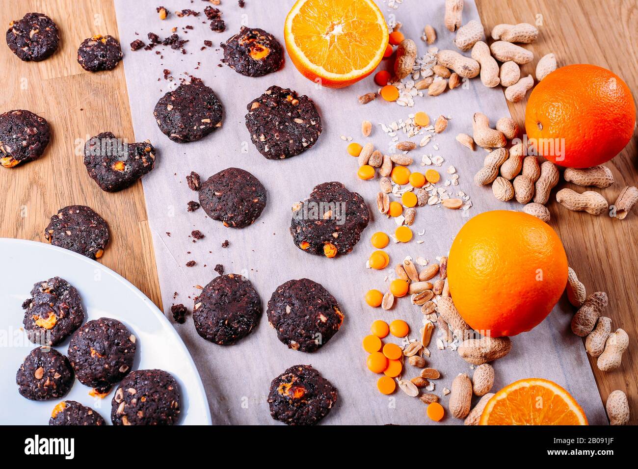 Handgefertigte Schokoladenplätzchen mit Orange und Zimt und Nüssen. Süßigkeiten, Schokolade, Zitrusfrüchte, Zimt. Draufsicht Stockfoto