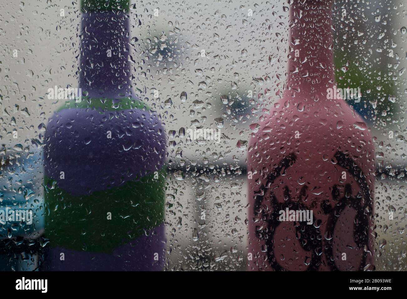 Am Frühlingnachmittag fällt Regen auf das Glas. Nahaufnahme eines Fensters mit herabfallenden Regenfällen.Der Regen fällt auf die Haushaltsfenster. Konzentrieren Sie sich auf Regen Stockfoto