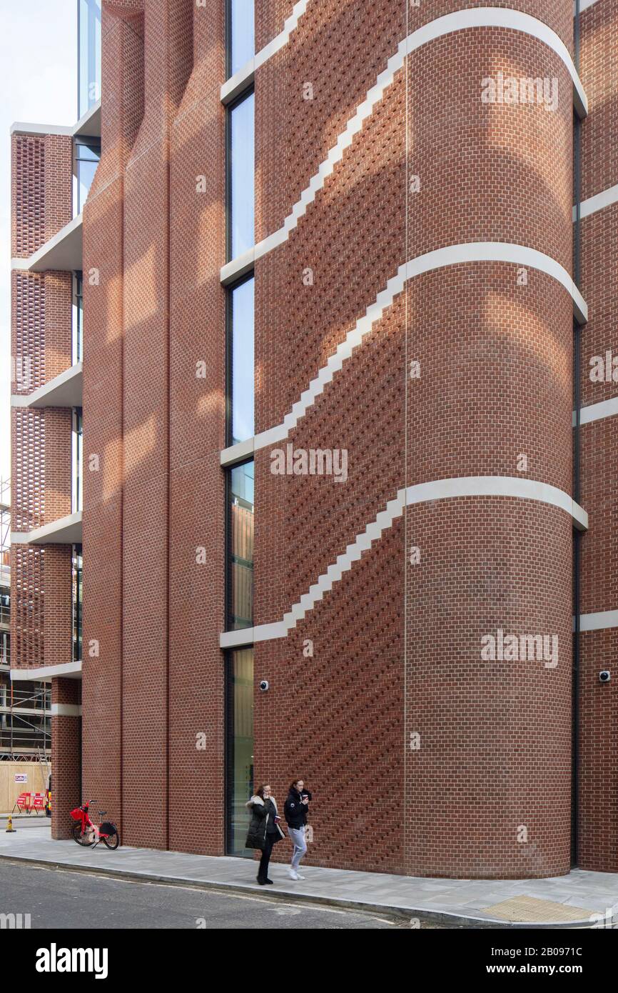 Breite Ansicht der gebogenen Ecke aus Backstein. UCLH Eye Hospital, London, Großbritannien. Architekt: Pilbrow und Partner, 2019. Stockfoto