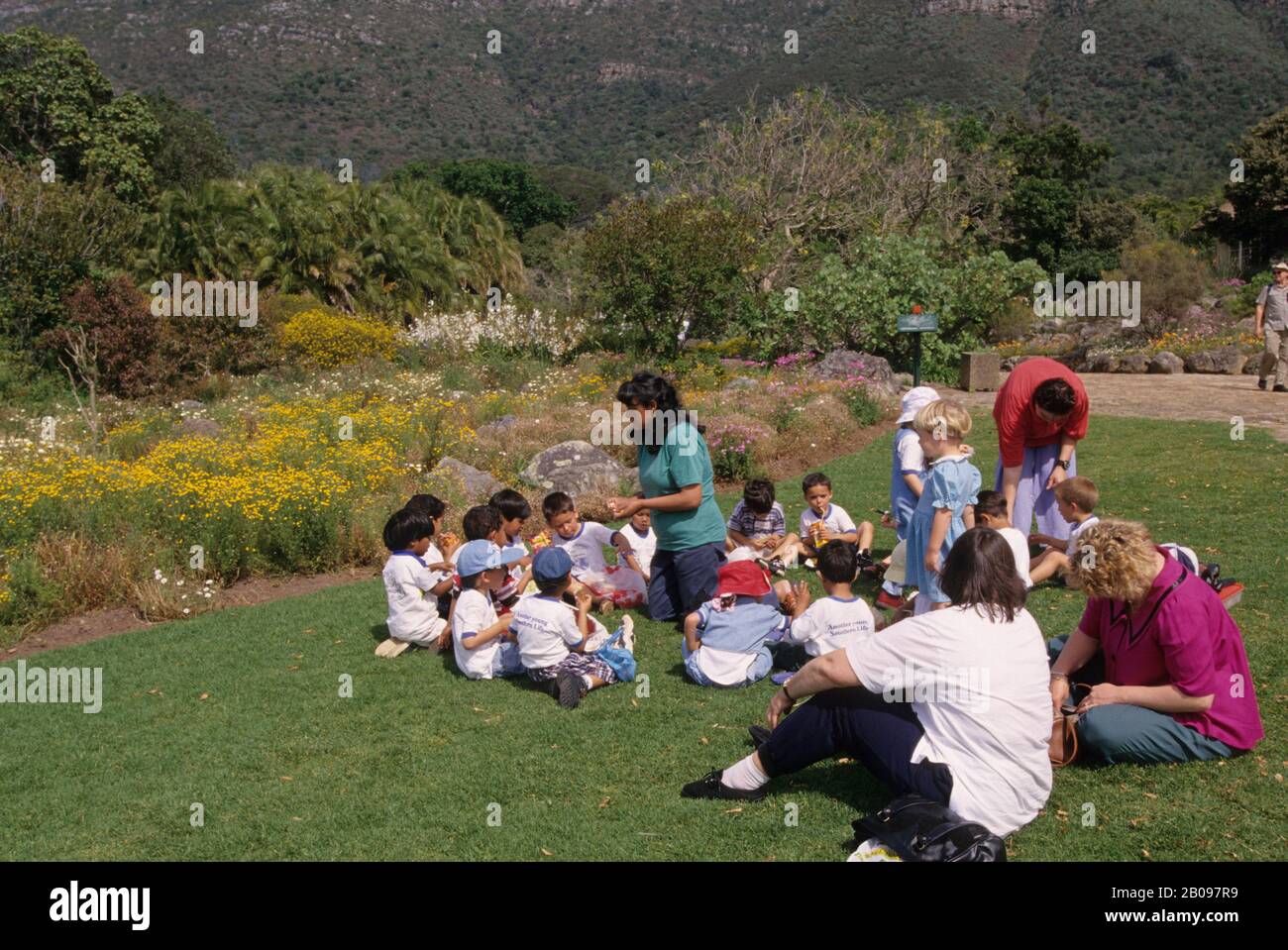 SÜDAFRIKA, KAPSTADT, KIRSTENBOSCH BOTANISCHER GARTEN, SCHULKLASSE MIT PICKNICK Stockfoto