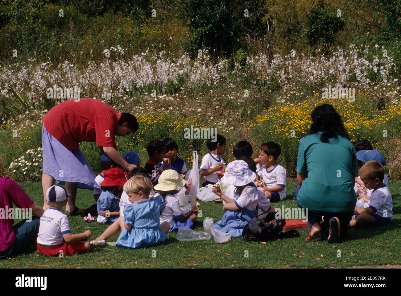 SÜDAFRIKA, KAPSTADT, KIRSTENBOSCH BOTANISCHER GARTEN, SCHULKLASSE MIT PICKNICK Stockfoto