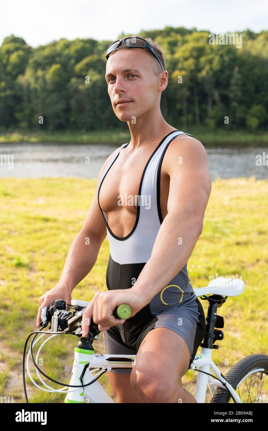 Ein Mann mit einem Fahrrad in der Natur. Im Feld, im Sommer. Stockfoto
