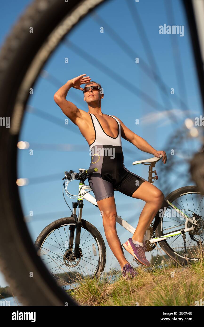Ein Mann mit einem Fahrrad am Seeufer. Stockfoto