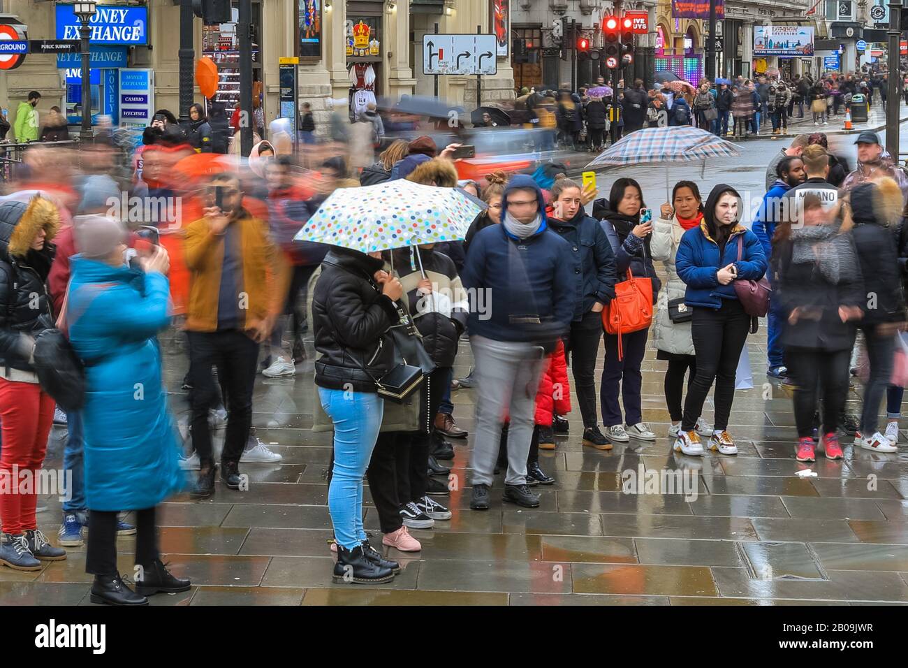 West End, London, Großbritannien. Feb. 2020. Touristen am Piccadilly Circus machen das Wetter am meisten. Touristen und Londoner machen an einem nassen, aber milden Tag im Londoner West End die meisten kurzen Regenlücken. Kredit: Imageplotter/Alamy Live News Stockfoto