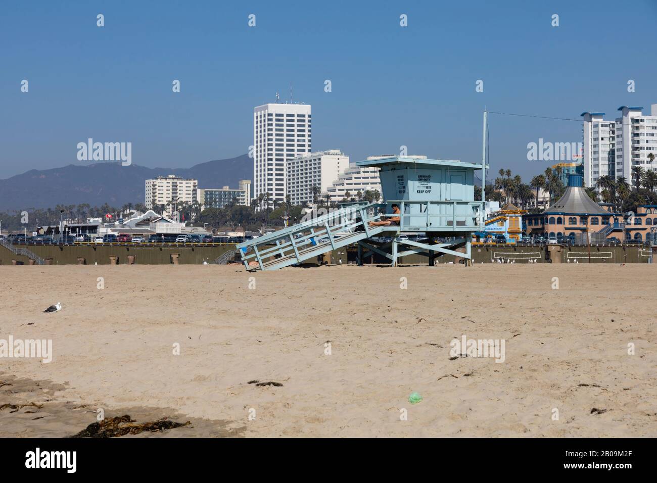 Der Strand und der Rettungsschwimmer Santa Monica. Das höchste Gebäude, 100 Wilshire, befindet sich im Hintergrund von Kalifornien, Vereinigte Staaten von Amerika Stockfoto