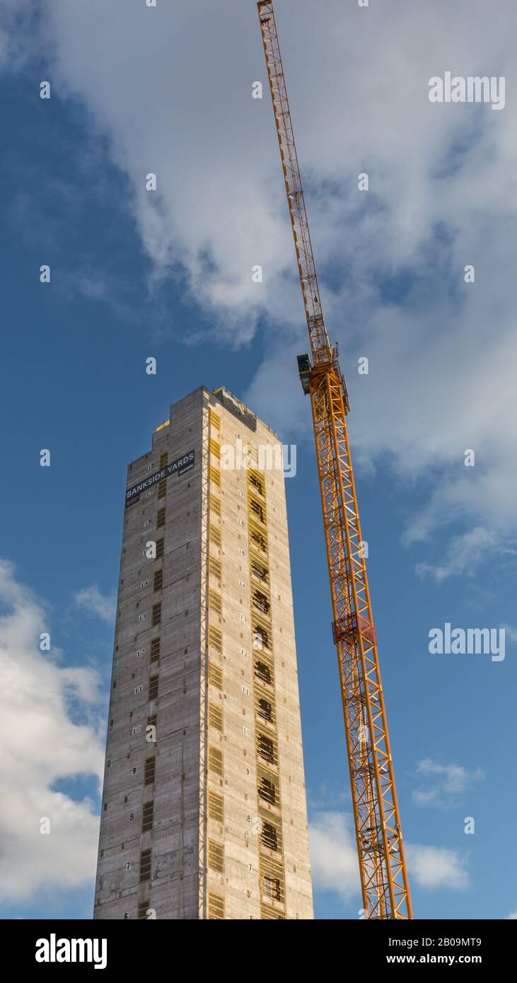 Wellenturm und Kran aus Betonelevator, hohes Gebäude im Bau mit markierten Geschichten gegen sonnigen blauen Himmel, Bankside Yards, Großbritannien Stockfoto