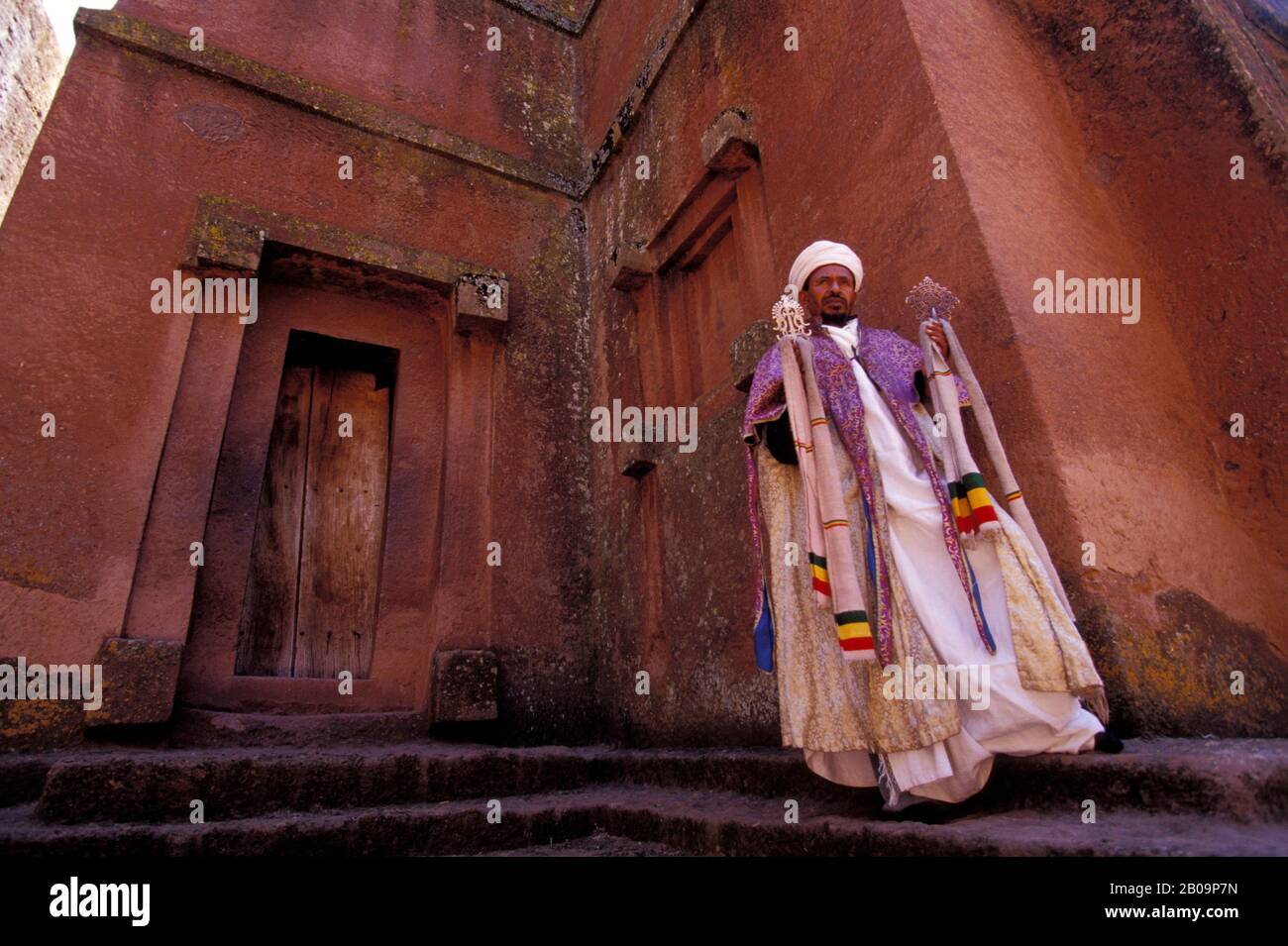 ÄTHIOPIEN, LALIBELA, UNESCO-WELTKULTURERBE, IN FELSEN GEHAUENE KIRCHE, KREUZKIRCHE, PRIESTER MIT KREUZ Stockfoto