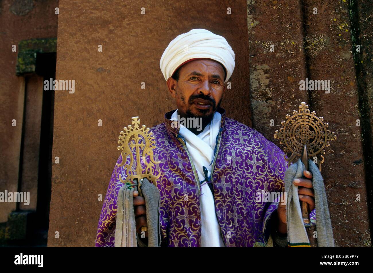 ÄTHIOPIEN, LALIBELA, UNESCO-WELTKULTURERBE, IN FELSEN GEHAUENE KIRCHE, KREUZKIRCHE, PRIESTER MIT KREUZ, NAHAUFNAHME Stockfoto