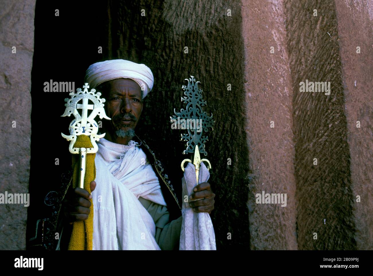 ÄTHIOPIEN, LALIBELA, UNESCO-WELTKULTURERBE, IN FELSEN GEHAUENE KIRCHE, PRIESTER MIT KREUZ Stockfoto