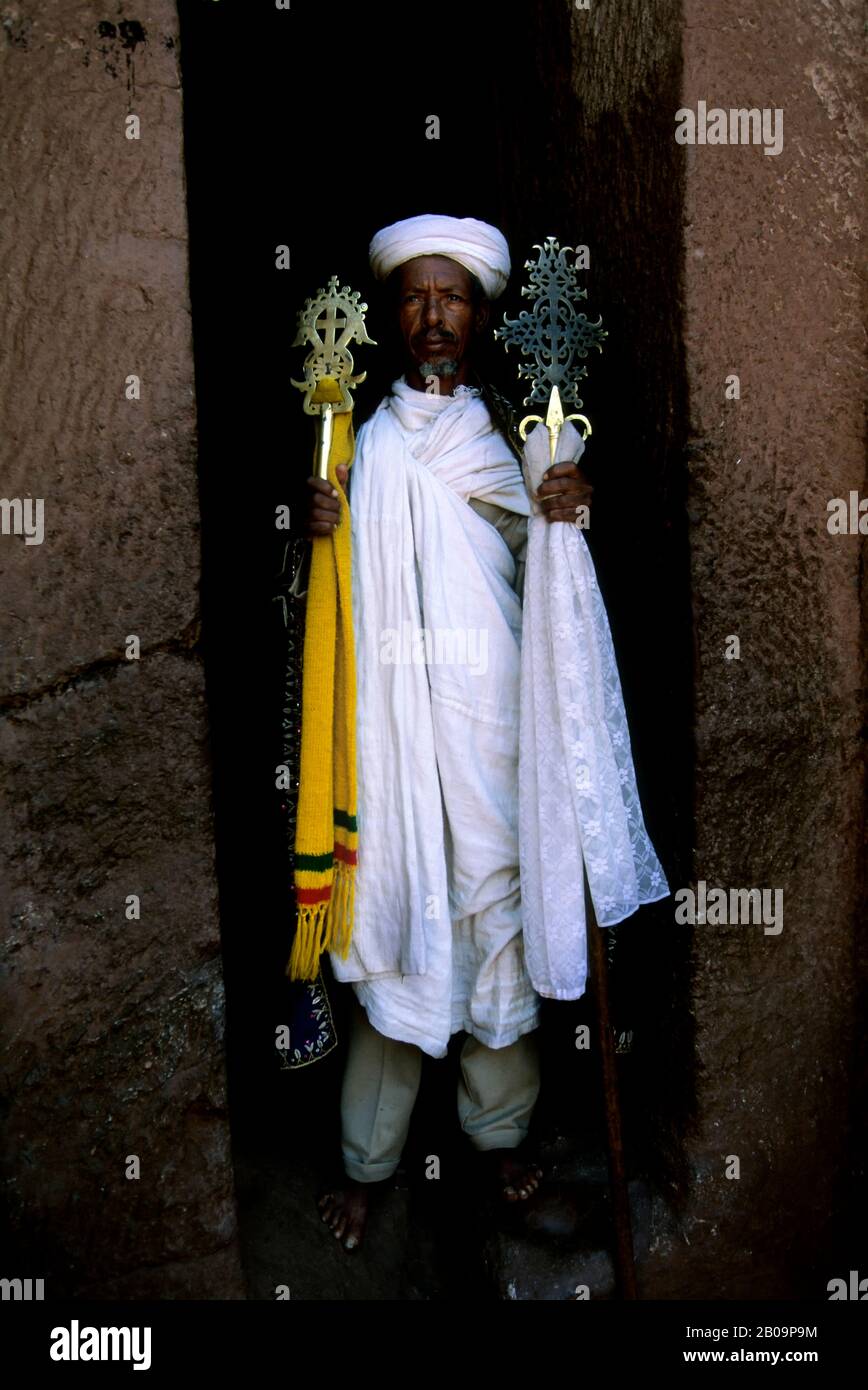 ÄTHIOPIEN, LALIBELA, UNESCO-WELTKULTURERBE, IN FELSEN GEHAUENE KIRCHE, PRIESTER MIT KREUZ Stockfoto