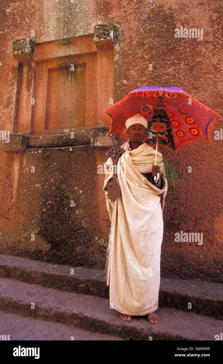 ÄTHIOPIEN, LALIBELA, UNESCO-WELTKULTURERBE, IN FELSEN GEHAUENE KIRCHE, PRIESTER MIT KREUZ Stockfoto