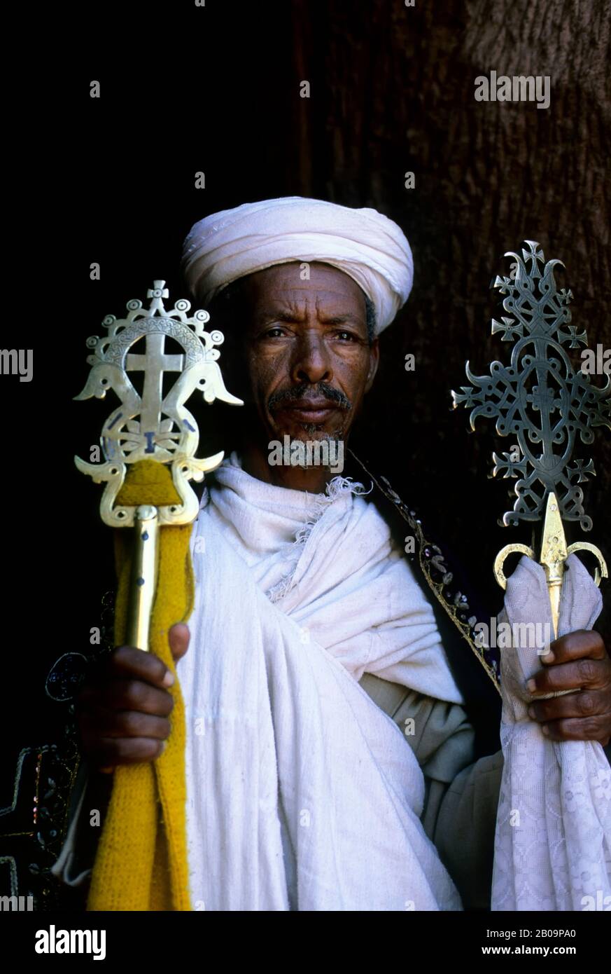 ÄTHIOPIEN, LALIBELA, UNESCO-WELTKULTURERBE, IN FELSEN GEHAUENE KIRCHE, PRIESTER MIT KREUZ Stockfoto