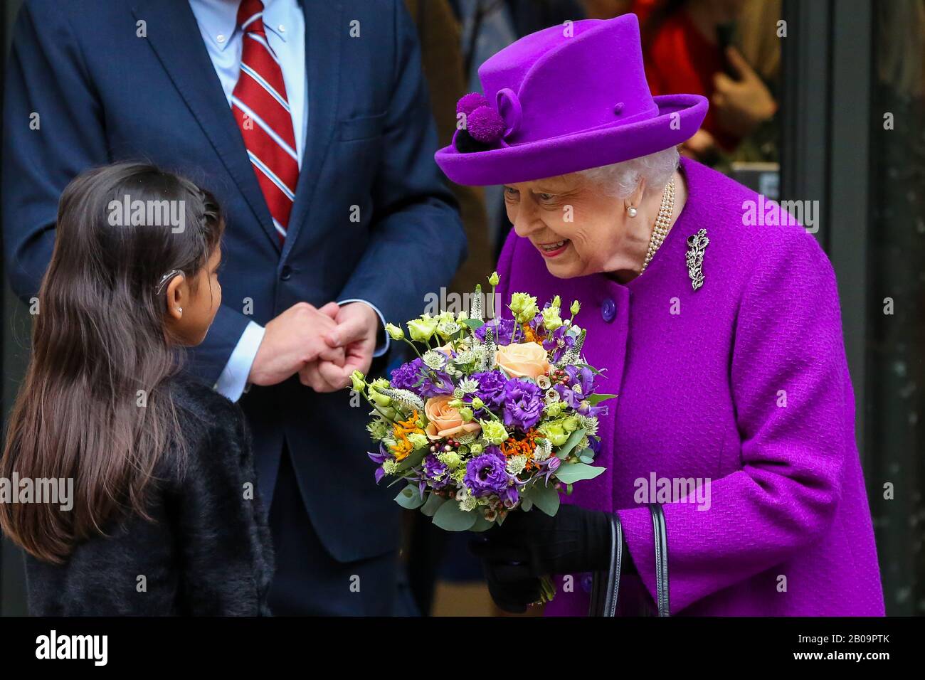 Ein junges Mädchen schenkt Königin Elizabeth II. Blumen, als sie das Royal National Throat, Nose and Ear Hospital und das Eastman Dental Hospital im Zentrum Londons verlässt, nachdem sie das neue Gelände eröffnet hat. Stockfoto