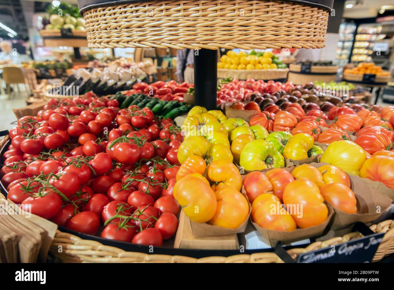 Gemüsekorb mit verschiedenen Tomaten und Gurken Stockfoto