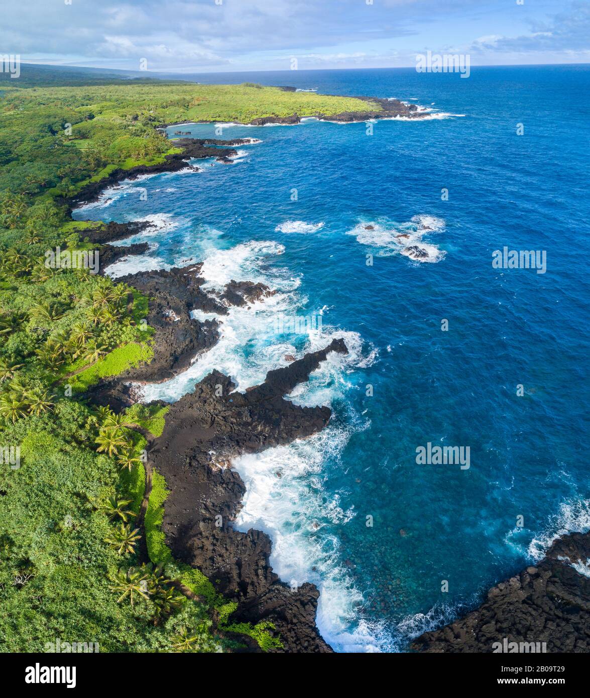 Ein Luftbild der Küstenlinie im Waianapanapa State Park, Hana, Maui, Hawaii. Der berühmte schwarze Sandstrand befindet sich in der Bucht oben auf dem Rahmen. Fiv Stockfoto