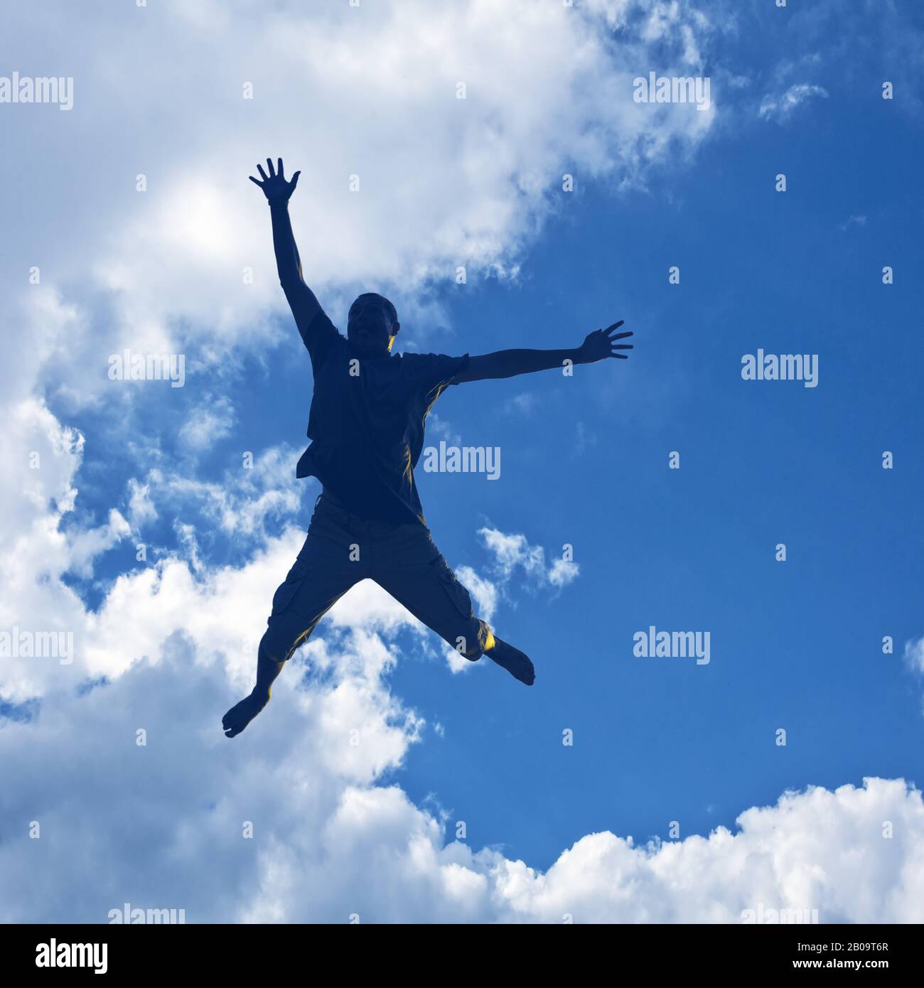 Silhouette Man springt in den Sonnenuntergang. Stockfoto