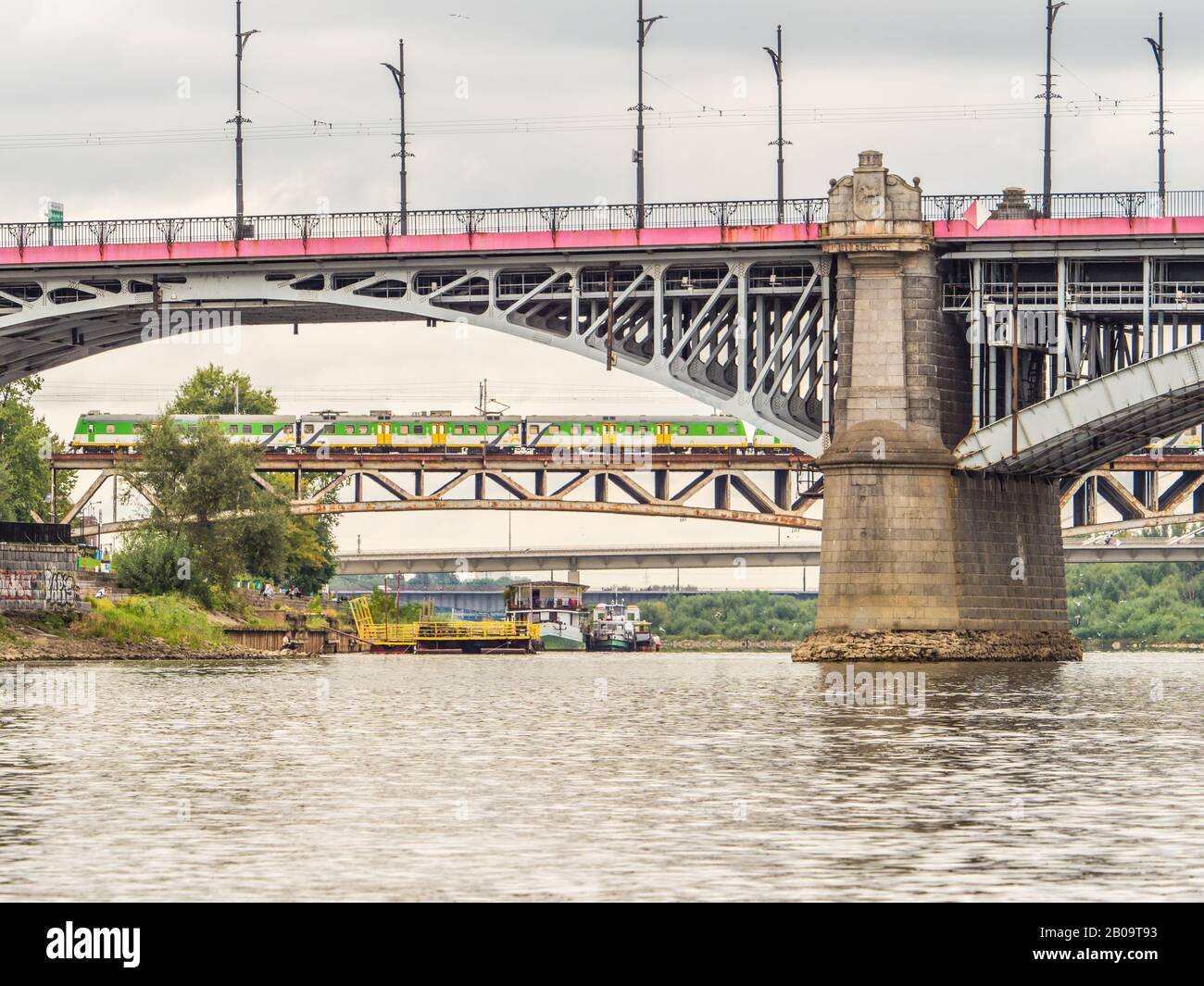 Warschau, Polen - 25. August 2018: Brücken an der Weichsel in Warschau. Poniatowski-Brücke auf dem ersten Plan, Züge auf der Srednicowy-Eisenbahnbrücke Fart Stockfoto