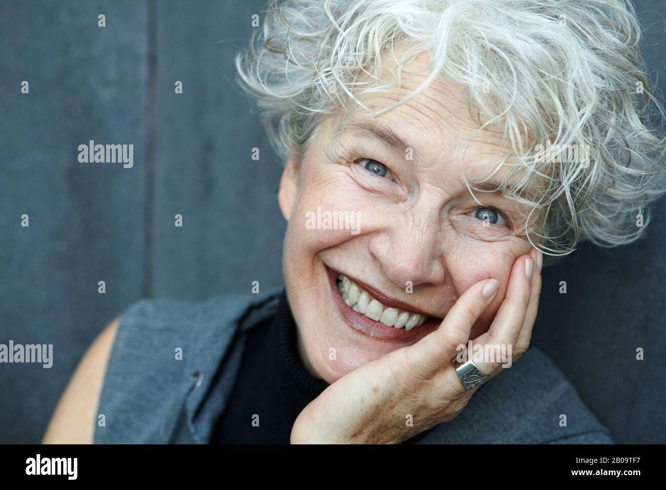 Fröhliche, lächelnde 65-jährige Frau Stockfoto