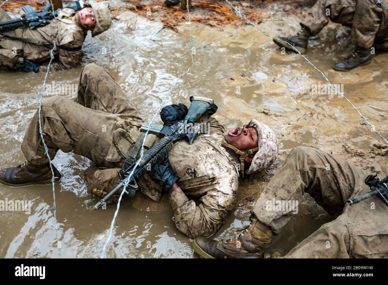 US Marine Corps rekrutiert sich mit Delta Company, 1st Recruit Training Battalion Manöver durch Schlamm und Stacheldraht während des Combat Endurance Course 21. Dezember 2019 bei Marine Corps Recruit Depot Parris Island, South Carolina. Stockfoto