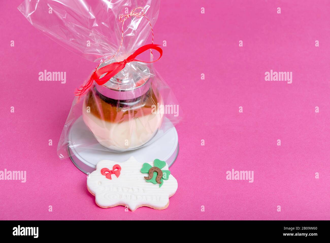 Mixbecher mit Cremes auf pinkfarbenem Hintergrund, schönes Geschenk im März Stockfoto