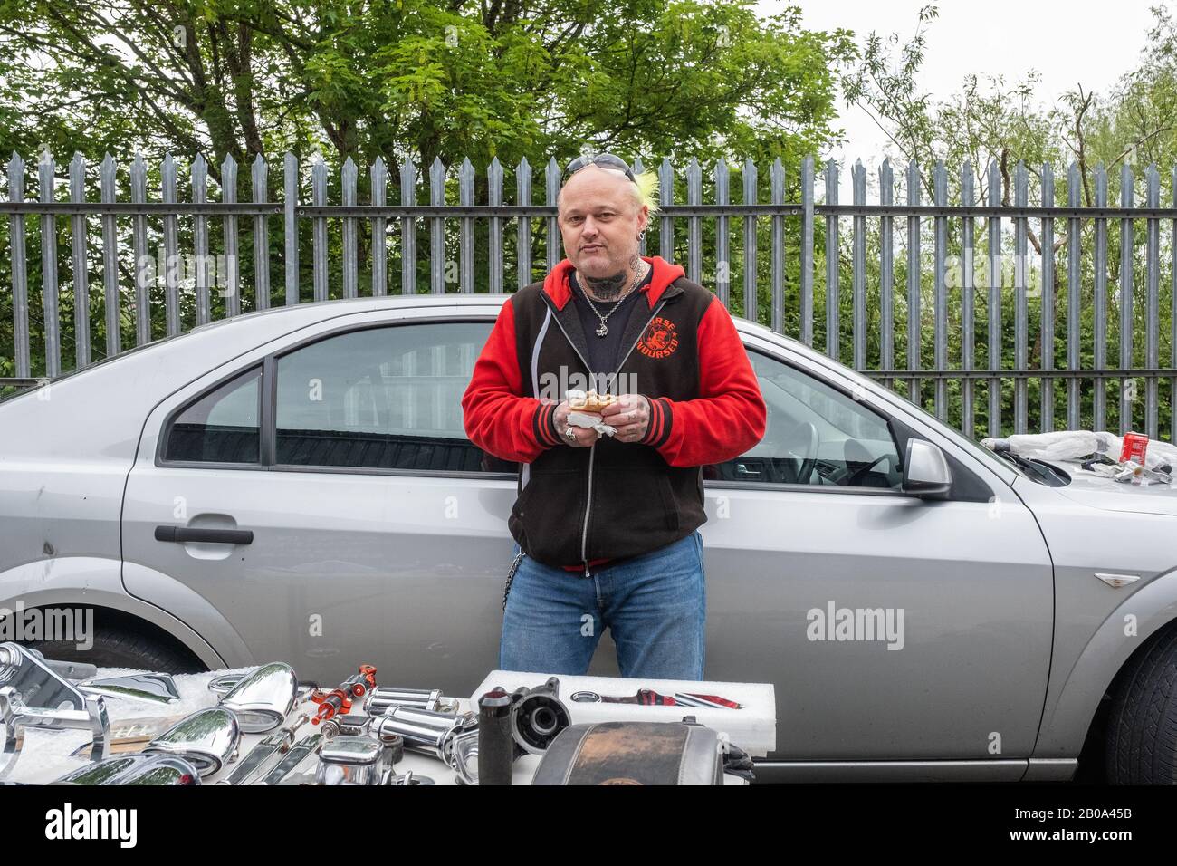 Mann mit funky Haarart verkaufen seine Harley-Motorteile bei Harley-Davidson Reading Berkshire England Stockfoto
