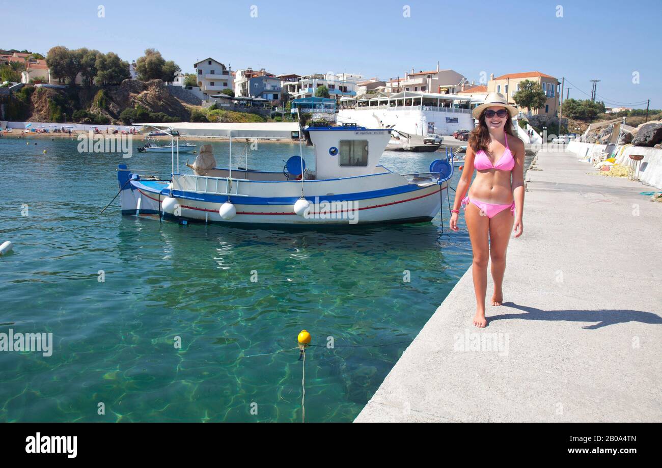Ein Mädchen im Teenager-Alter (Modell veröffentlicht) spaziert an der Hafenquerseite im alten Fischerdorf Panoramos ( Panormo ) auf Crete. Stockfoto