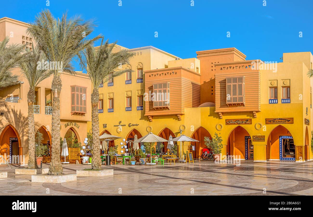 Ein Restaurant mit Sonnenschirmen und farbenfrohen ägyptischen Häusern an der Marina Piazza in El Gouna, Ägypten, 17. Januar 2020 Stockfoto