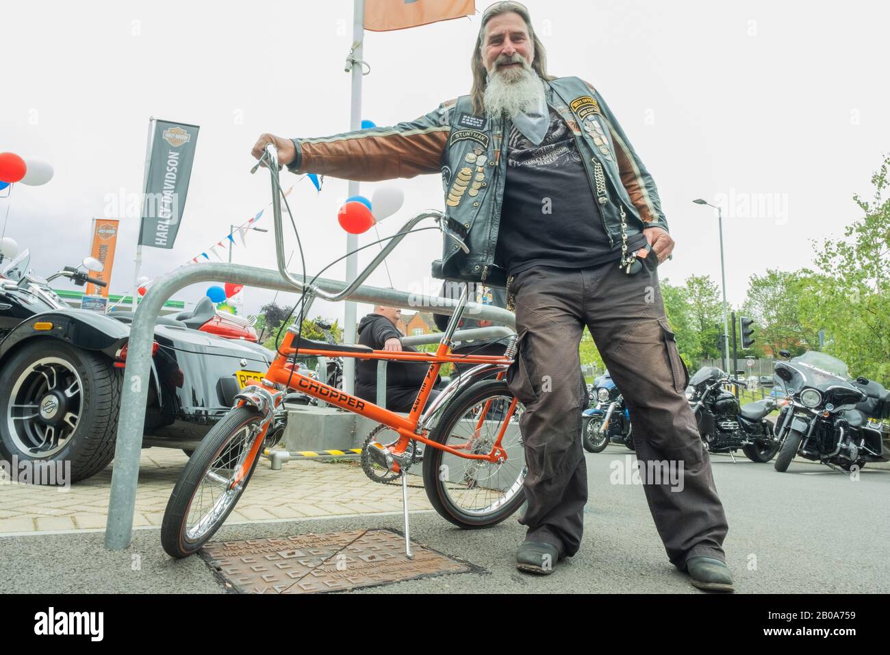 MCC Biker posiert von einem Kids Chopper bei Harley-Davidson Reading Berkshire England Stockfoto