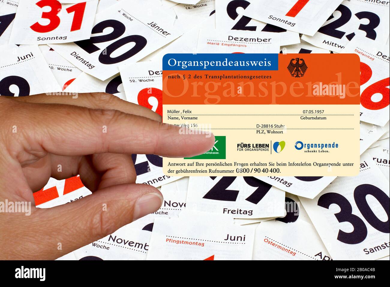 Hand, die eine Organspenderkarte vor Kalenderblättern hält, komponieren, Deutschland Stockfoto