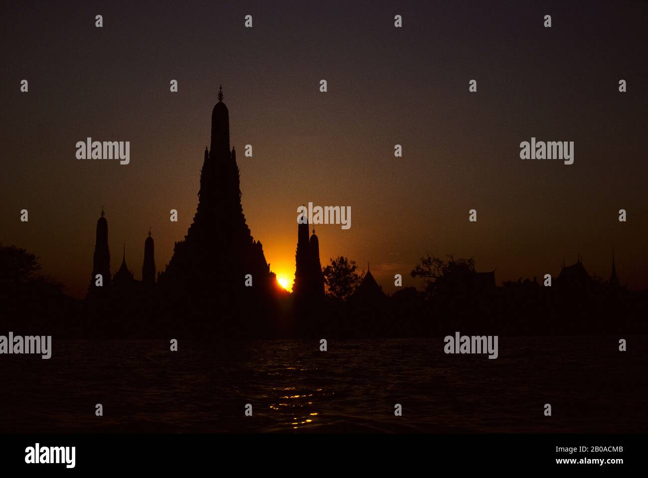 THAILAND, BANGKOK, WAT ARUN (TEMPEL DER MORGENDÄMMERUNG) SILHOUETTE BEI SONNENUNTERGANG MIT MAE NAM CHAO PHRANG FLUSS Stockfoto
