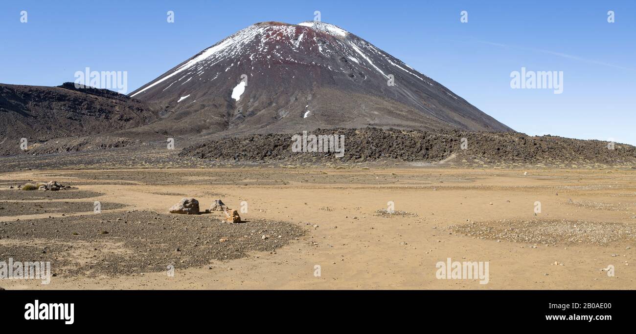 Vulkanische staubige Landschaft, mit einem Vulkan mit Schnee im Hintergrund Stockfoto