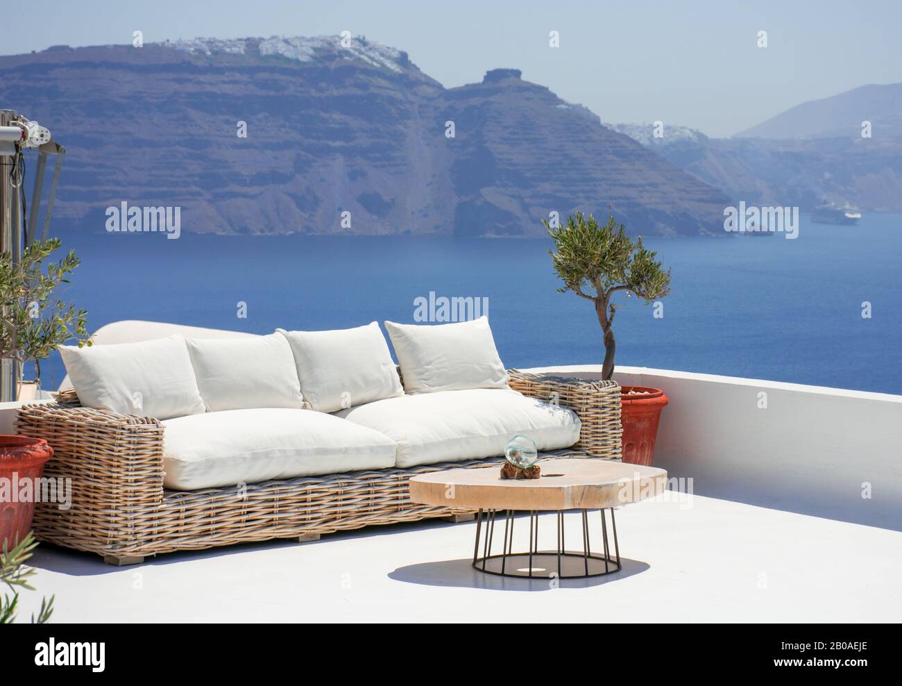 Schöne Terrasse mit Sofa und kleinem Tisch im Dorf Oia auf der griechischen Insel Santorini. Niemand genießt jetzt das spektakuläre Panorama Stockfoto