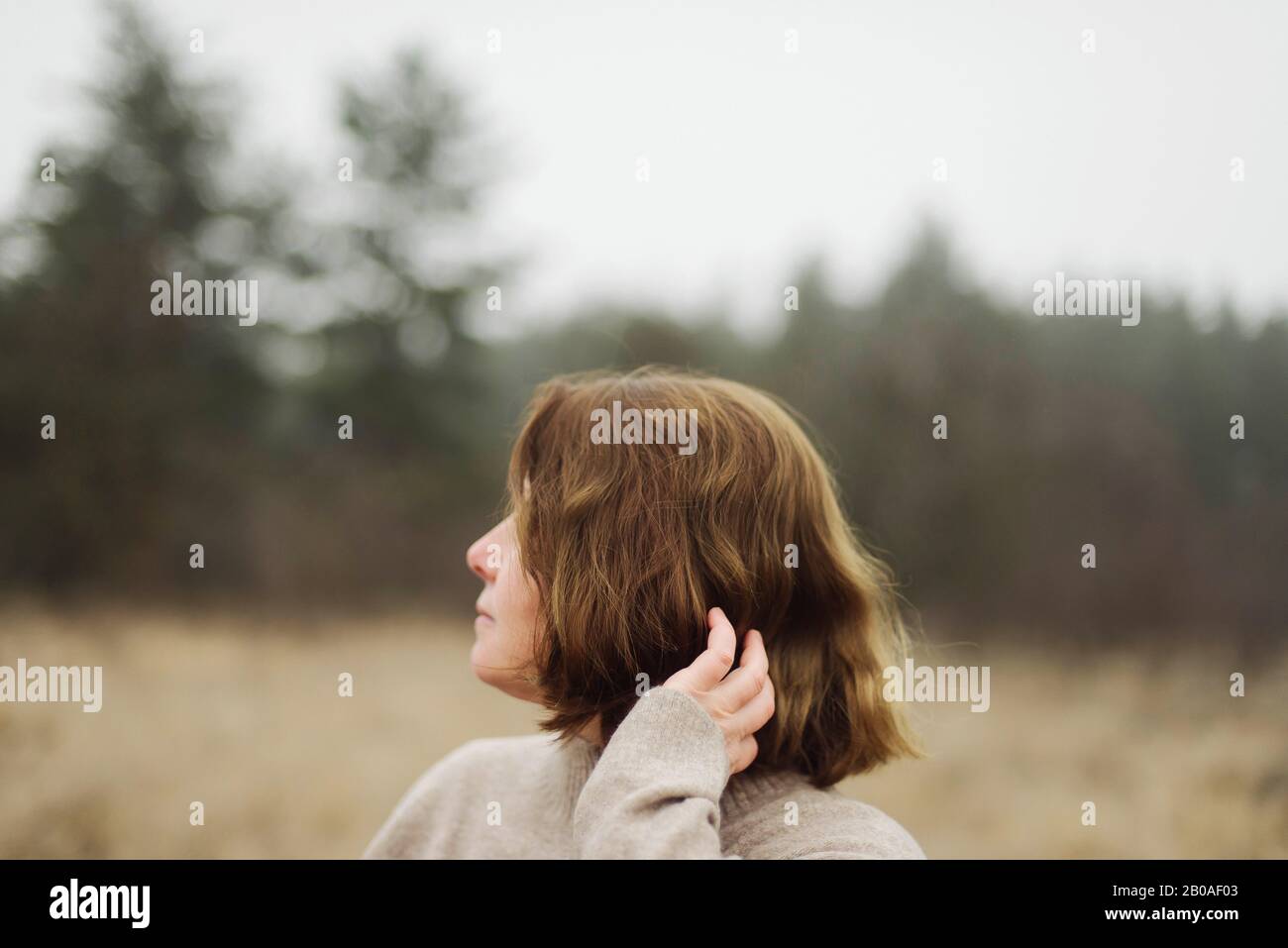 Frau steht am Wald bei nebeligem Wetter Stockfoto