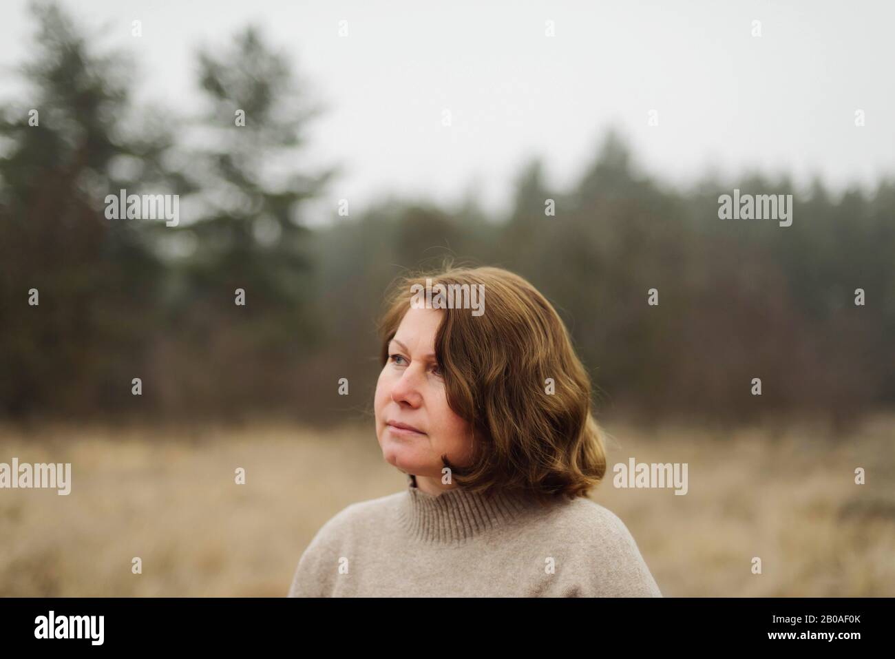 Frau steht am Wald bei nebeligem Wetter Stockfoto