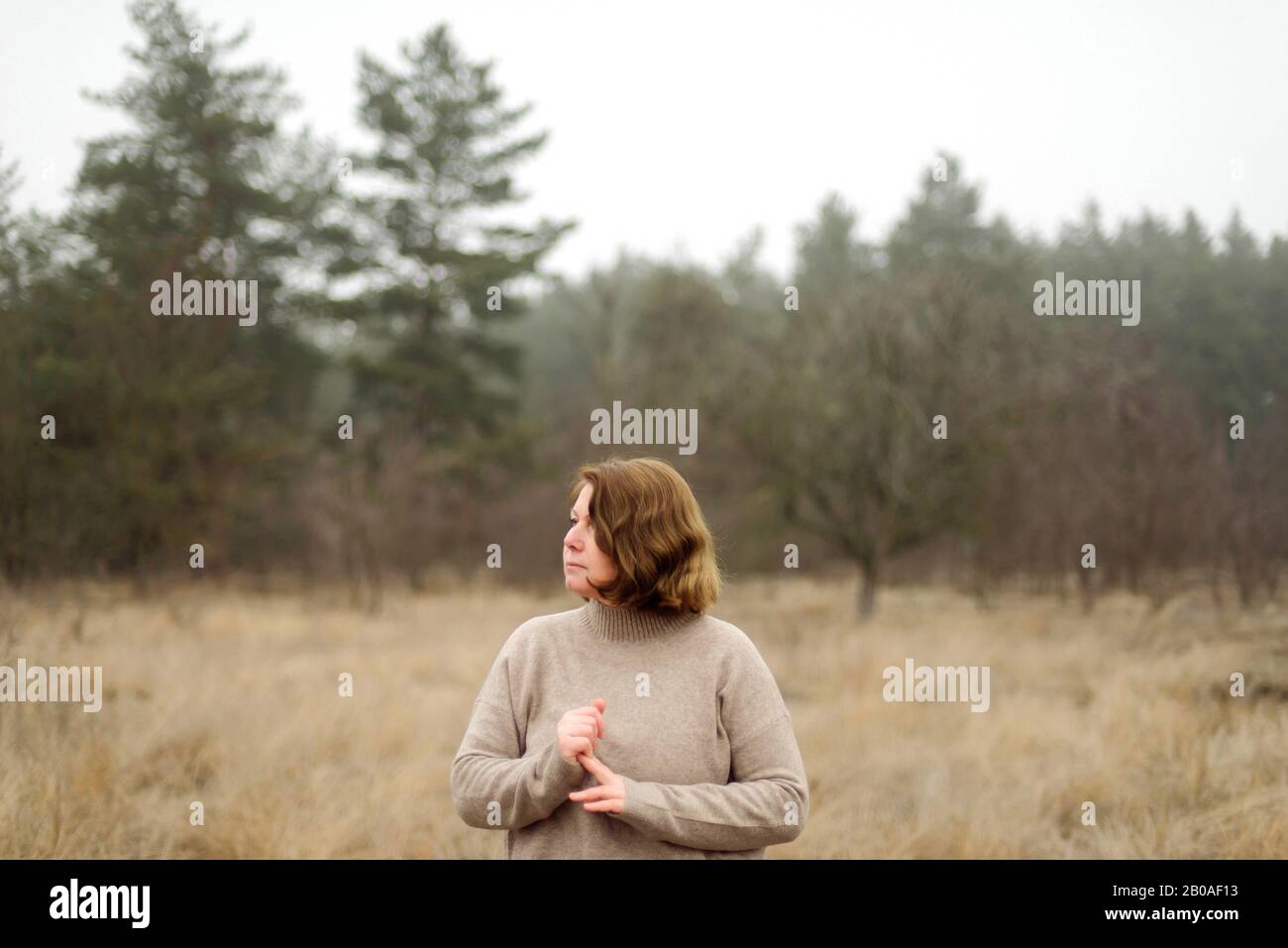 Frau steht am Wald bei nebeligem Wetter Stockfoto