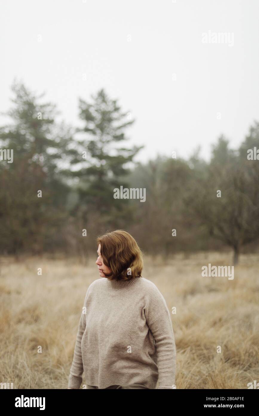 Frau steht am Wald bei nebeligem Wetter Stockfoto