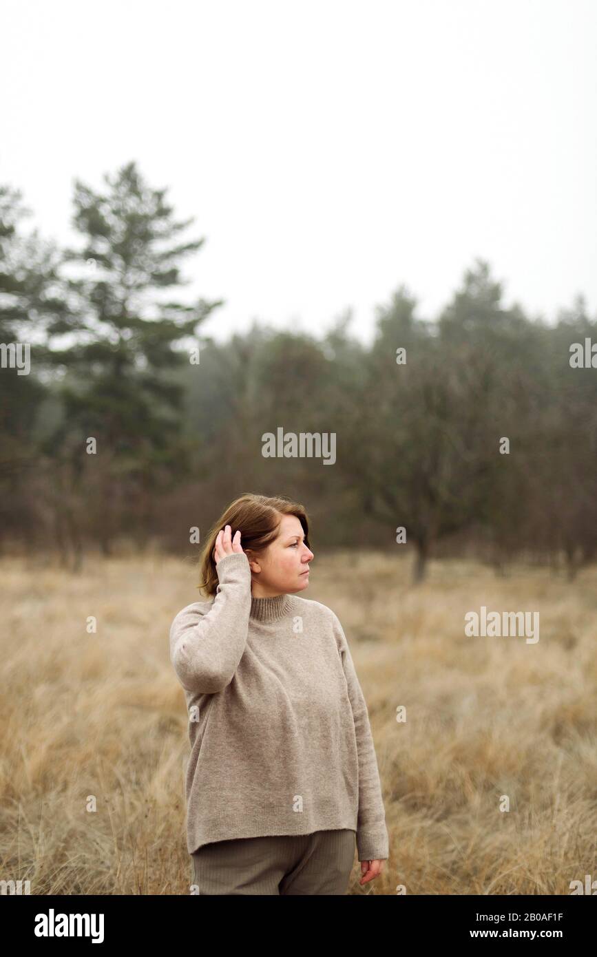 Frau steht am Wald bei nebeligem Wetter Stockfoto