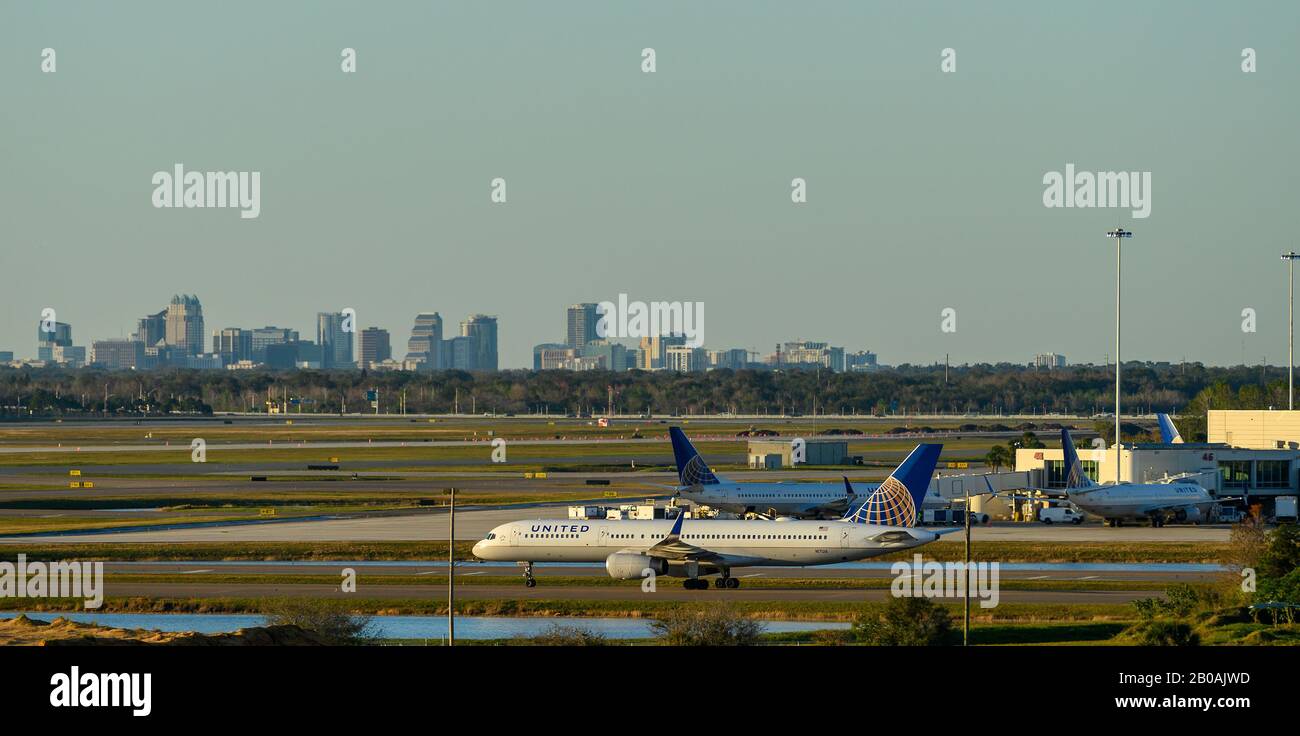 United Airline Airplanes am Orlando International Airport mit der Skyline der Innenstadt Orlandos im Hintergrund. Stockfoto