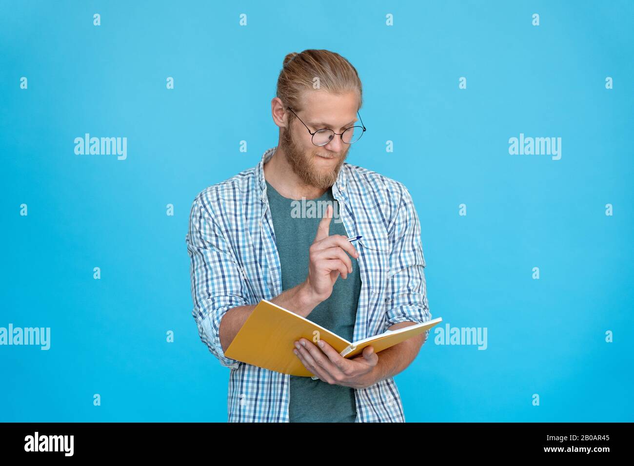 Junger nachdenklicher träumerischer Mann hält Stift, denkt, Plan macht Notizen Tagebuch Stockfoto