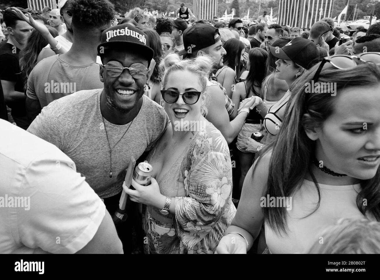 Ein gemischtes Rassenpaar, das sich in der Tanzmenge verspotelt und für ein soziales Foto posiert - Ein Musikfestival in Sydney, Australien Dokumentiert Stockfoto