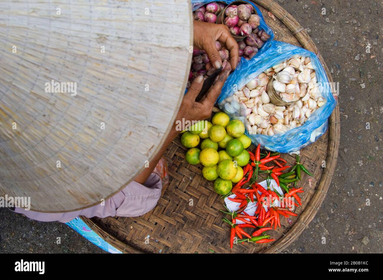 VIETNAM, HUE, MARKET, FRAU MIT CHILIPEIPPERN, LIMETTEN UND ZWIEBELN Stockfoto
