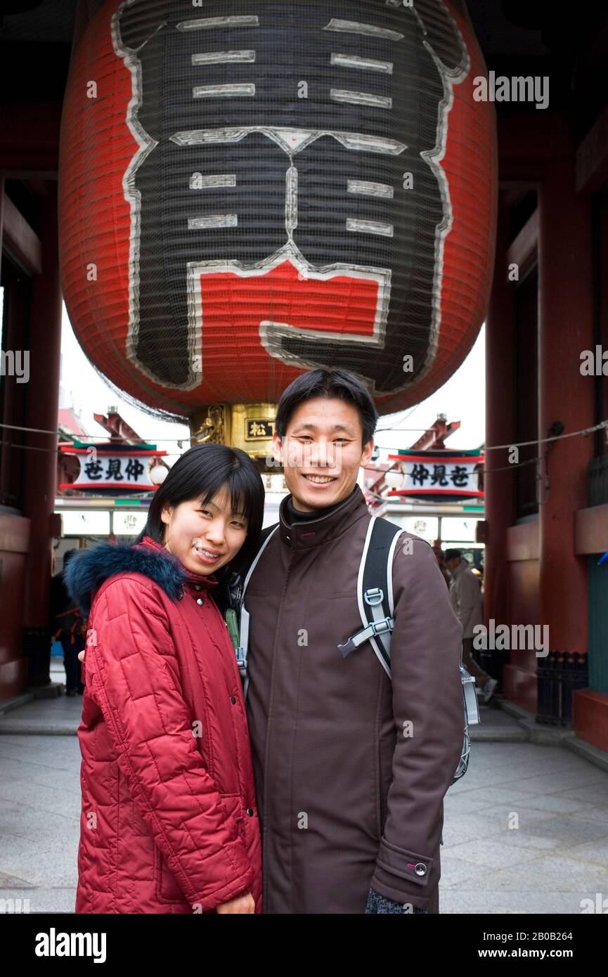 JAPAN, TOKIO, ASAKUSA SENSOJI BUDDHISTISCHER TEMPEL, JUNGES JAPANISCHES PAAR, DAS VOR DEM TOR POSIERT Stockfoto